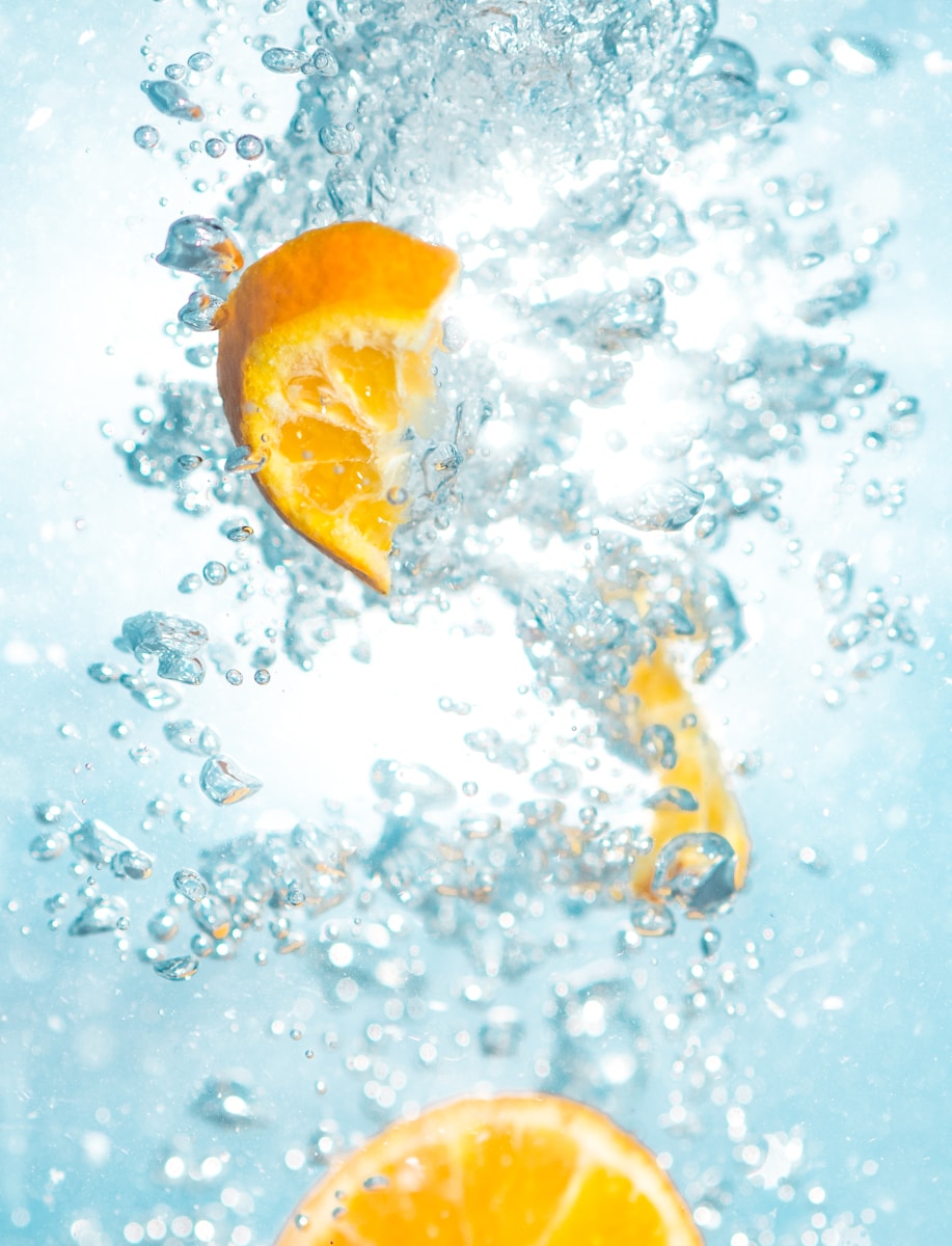 sliced orange fruits underwater showing hydration drinks